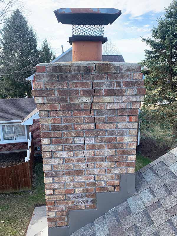 A chimney with red bricks and a crack down the side