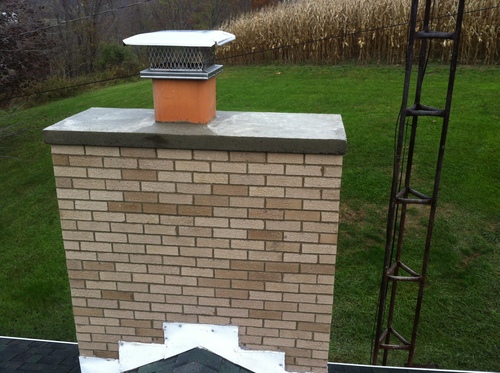 New silver crown on a beige chimney with green grass in the background