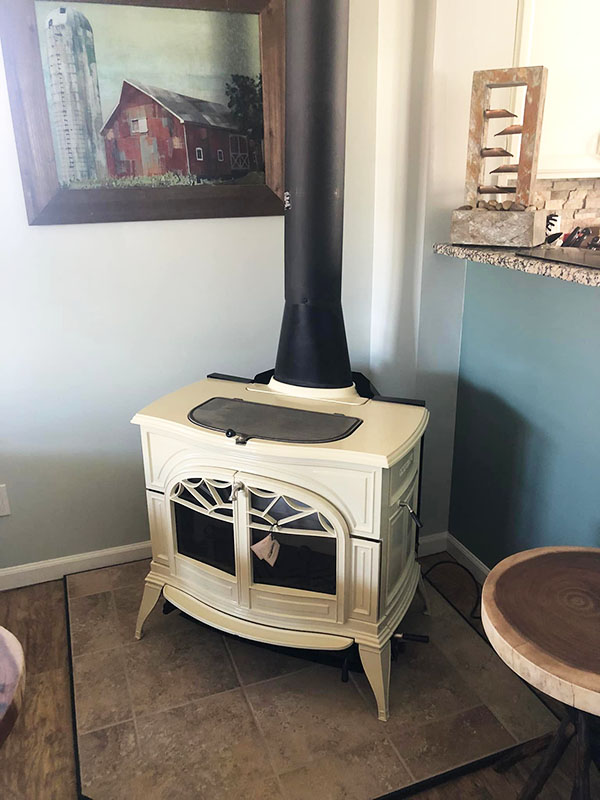 A white Vermont Casting wood stove over tile